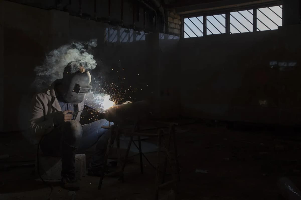 Welder performing MIG welding on a steel frame at RCM Metal Works in Murray, Utah